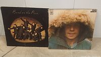 Front covers of Wings Band on the Run and Paul Simon vinyl records showing album art.