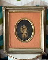 Full view of antique wood frame with peach velvet mat and oval photo of woman