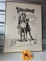 Full view of framed black and white art poster showing two Shakespearean characters with text: 'The National Shakespeare Company Presents Twelfth Night'. Frame is polished gold metal with visible crack on lower right corner of glass.