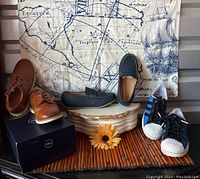 Three pairs of boys shoes displayed: brown lace shoes on box, blue loafers in front, and Adidas sneakers on right