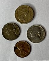 Obverse side of four coins showing Queen Elizabeth II on the 1984 British one pound coin, and profiles of Thomas Jefferson and Abraham Lincoln on three US coins.