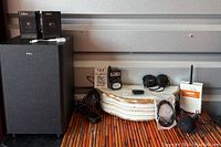 Full lot view with speaker, microphones, adapters, cables and communication devices arranged on wooden surface.