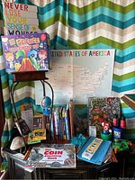 Full overview of the educational books, science kit in box, wall art, maps, Ninja Turtle binder, and craft supplies arranged on a small table.
