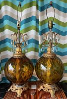Pair of amber glass globe lamps with crystal droplets and metal bases, hanging wires extending upward