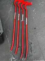 Four red Craftsman pry bars laid out showing full length and bent claw ends