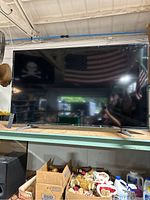 Front view of LG TV on wooden shelf showing entire screen and stand