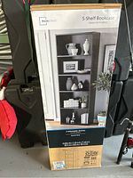 Full view of boxed bookcase showing packaging with Mainstays branding and image of the bookcase in use.