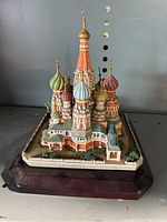 Front and side view of the miniature St Basil's Cathedral showing colorful dome details and architectural design on a wooden base.