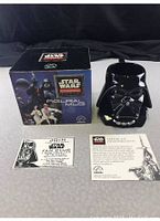 Photo of the Darth Vader shaped ceramic coffee mug, original box, and membership papers.