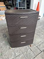 Front view of four drawer plastic storage container showing faux woven design and silver handles.