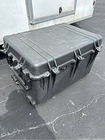 Large black Pelican 1650 case closed, showing its rectangular shape and wheels on bottom for transport.