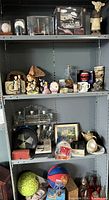 Photo of multiple shelves holding a variety of items including collectibles, figurines, sporting goods and home decor pieces.