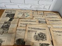 Multiple issues of The Youth’s Companion newspapers spread out showing front pages and some internal pages, with visible wear, yellowing and age marks.