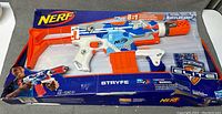 Full view of the Nerf Stryfe Elite blaster in original packaging showing the blaster and box damage.