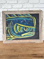 Frontal view of original dolphin fish painting on wooden canvas showing bright yellow, blue, teal, and purple colors with rustic wooden frame.
