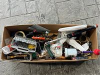 Box lot containing various painting and craft tools including paint sprayer, rollers, tape, craft sticks, and mixing paddle