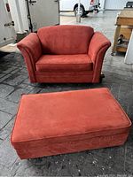 Red single sleeper sofa and matching ottoman closed, sofa missing feet visible.