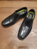 Pair of men's black leather Bostonian Commonwealth loafer shoes shown from top view revealing sleek design and squared toes.