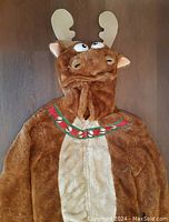 Front view of the brown plush moose costume showing the hood with antlers and decorative collar detail.