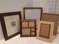 Set of five picture frames displayed upright on a white countertop.