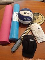 Photo showing full contents of the lot including two yoga mats, volleyball, two pairs of knee pads, and squash racquet