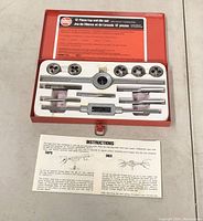 Open red metal case showing the 12 piece tap and die set inside with instructions.