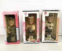 Photo showing the three bobble head dolls in original boxes: baseball player labeled RIP WICKER, and hockey players labeled WORTHY and PRONGER.