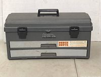 Closed view of gray Flambeau Bench Brute toolbox with black PowerLatches, handle and branding stickers