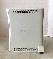 Side view of white Microsoft Xbox 360 console showing ventilation and Xbox 360 logo embossed on side panel.