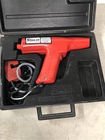 Snap-on MT241A red timing light tool with cables and clamps in the black carrying case, unit has label and ergonomic pistol grip, cables coiled alongside tool.