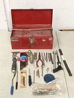 Red DIY Mark metal toolbox open showing assorted tools laid out in front