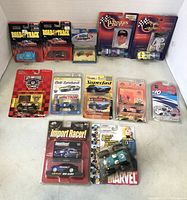 Front view of all die-cast cars and collectibles arranged on flat surface, mostly in original packaging.