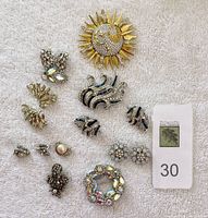 Overview of multiple signed costume jewelry pieces on white towel