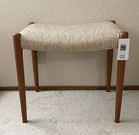 Front view showing beige tweed seat and teak legs with lot tag
