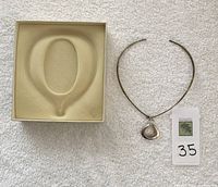Top view of original presentation box and necklace with pendant laid on towel background