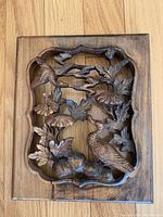 Front view of antique Chinese carved wood panel depicting birds and flowers with a scalloped border, natural wood tone.