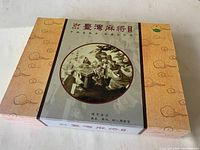 Image of the Mahjong set storage box closed, showcasing decorative exterior with traditional Chinese artwork and calligraphy.