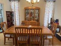 Full view of dining table, six chairs, and china cabinet in dining room