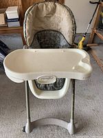 Front view of Evenflo baby adjustable high chair showing padded seat and plastic tray