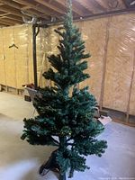 Full view of the artificial Christmas tree showing green branches and overall height.