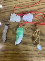 Clear overhead photo of all four items showing size and details of pendants and pin