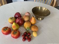 Full lot display showing all stone/jade fruits and the brass bowl on a white table.