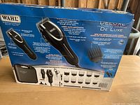 Packaging box for Wahl Deluxe haircutting kit showing product images, features, and accessories included.
