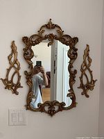 Photo of 3-piece wall mirror set including ornate mirror and two candle holders