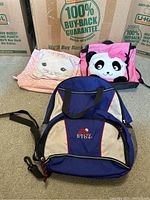Front view of the three bags showing the pink cat purse, panda backpack, and RLX backpack.