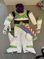 Full view of Buzz Lightyear inflatable costume laid out on floor showing boots, gloves, belt and headpiece.