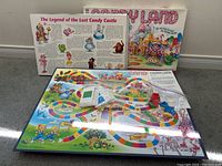 Candy Land board game with colorful board, characters, game cards, and playing pieces in bags with box