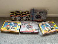 Image showing seven boxed vehicle construction toy sets with colorful packaging, some with transparent windows and plastic cases.