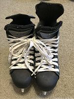 Front view of both black and gray Easton hockey skates showing laced uppers and toe area.