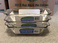 Stacked set of three clear glass loaf dishes with anchor hocking oven originals label visible, showing new items.